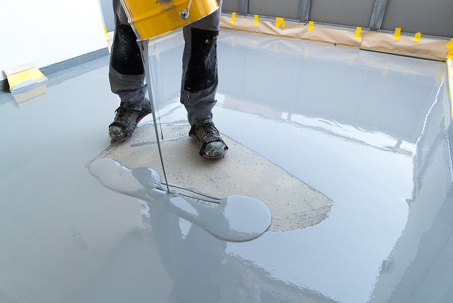 man pouring the epoxy in the floor